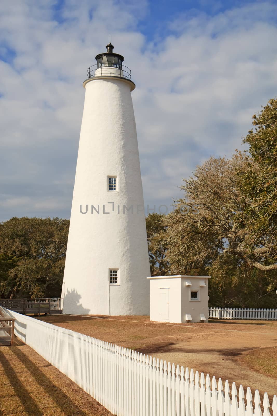 White picket fence leads past the tower of the Ocracoke Island lighthouse on the outer banks of North Carolina, the second-oldest operating lighthouse in the United States