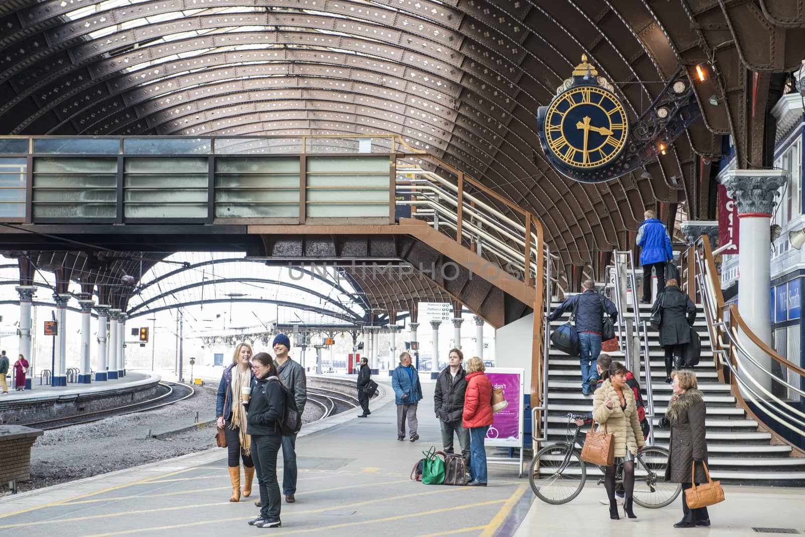 YORK, UK - MARCH 31: Passengers at platform in York Railway Station. Inaugurated in 1877 and bombed during WW2, it is one of the most important railway junctions in the British network. March 31, 2013 in York.