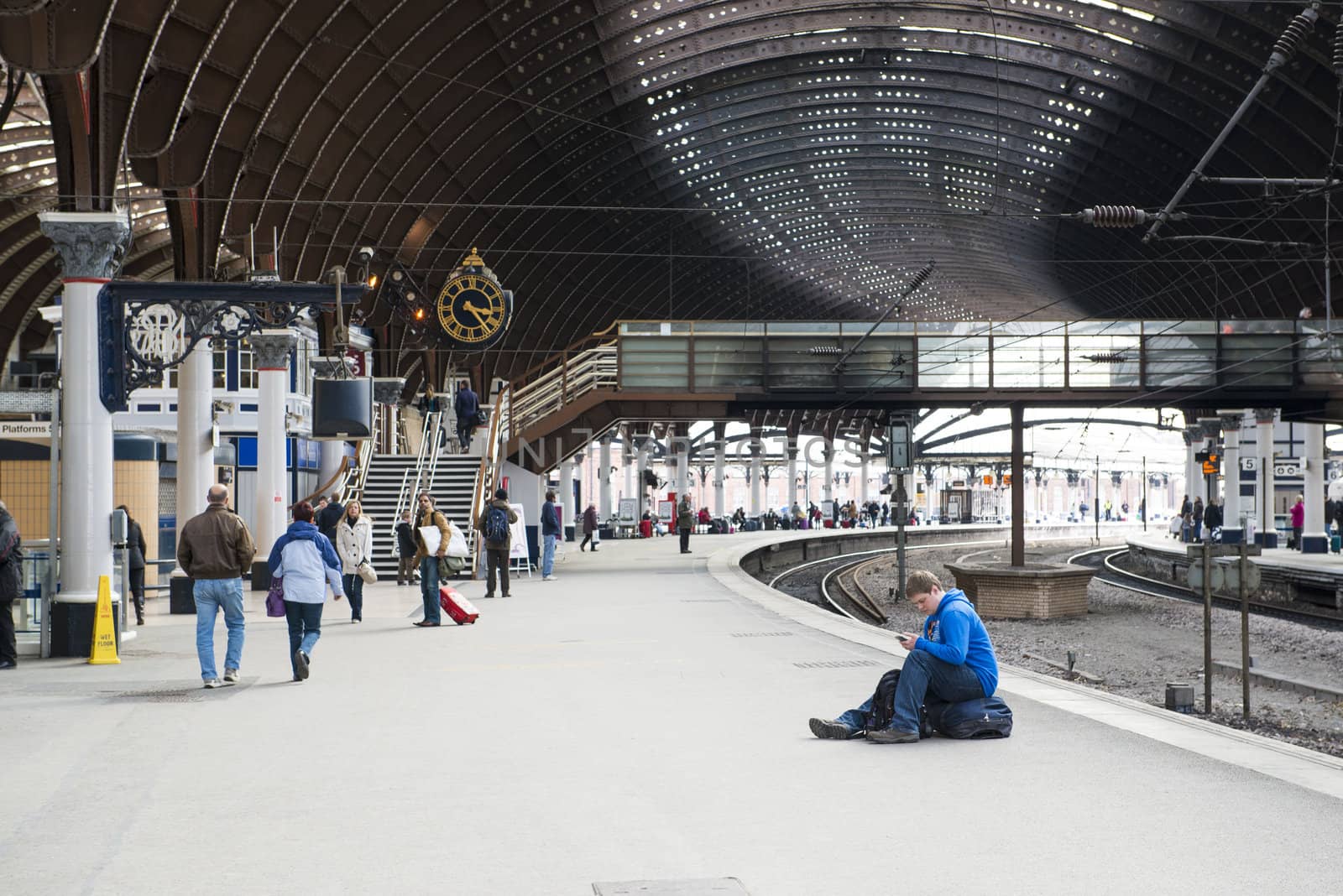 YORK, UK - MARCH 31: Passengers at platform in York Railway Station. Inaugurated in 1877 and bombed during WW2, it is one of the most important railway junctions in the British network. March 31, 2013 in York.