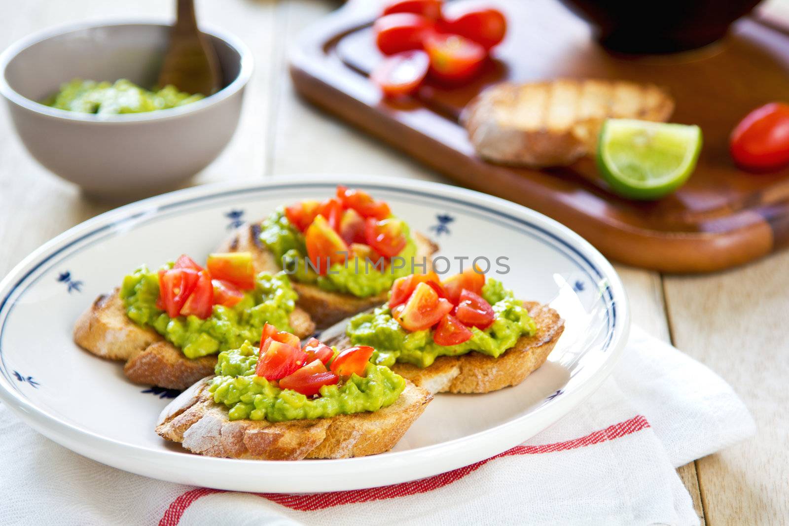 Crostini with avocado and tomato by vanillaechoes