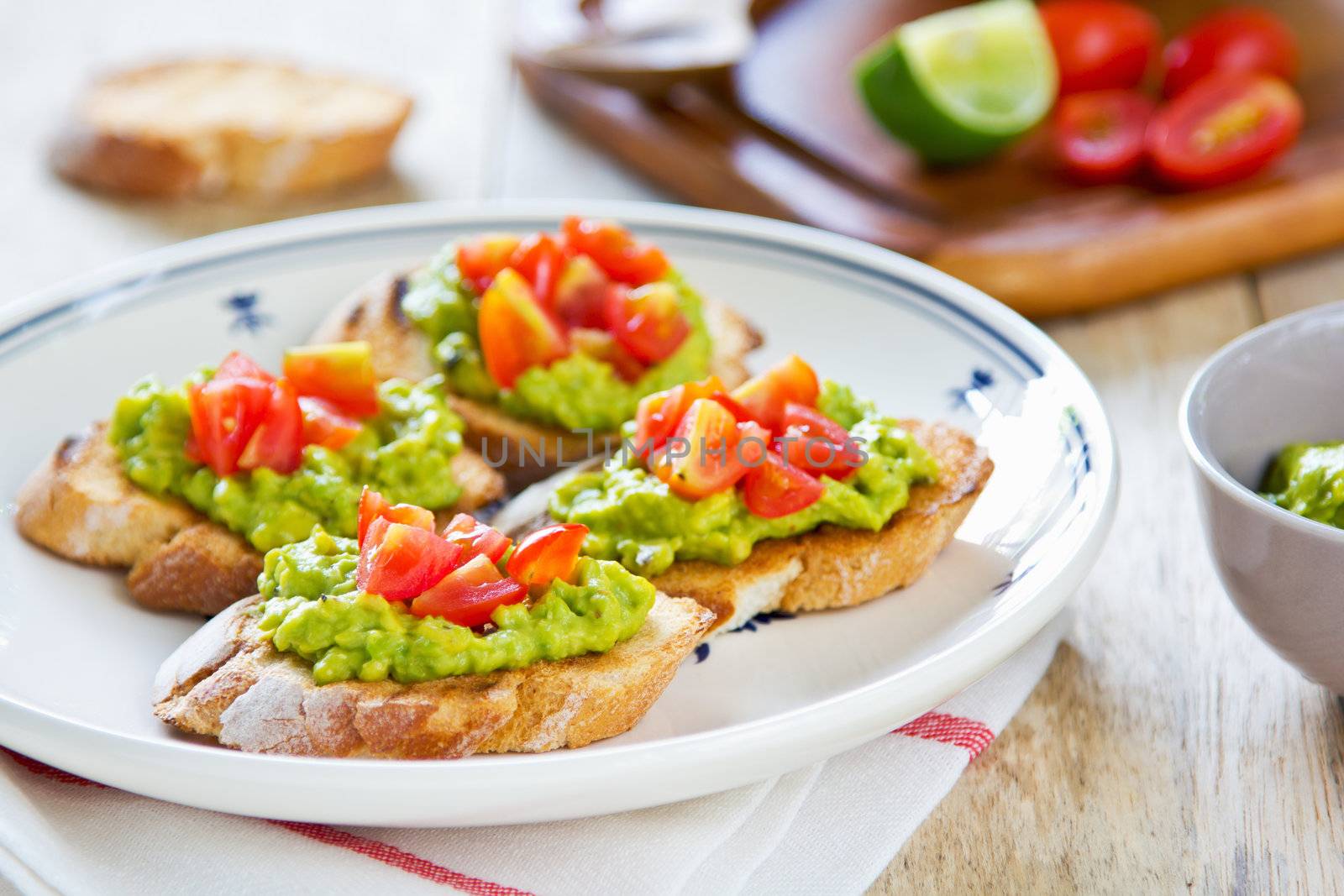 Crostini with avocado and tomato by vanillaechoes
