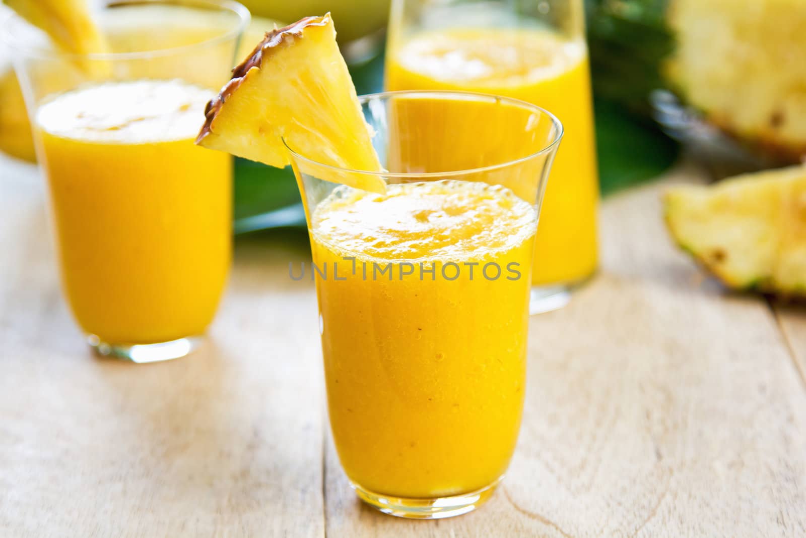 Mango with pineapple smoothie in jug and glasses