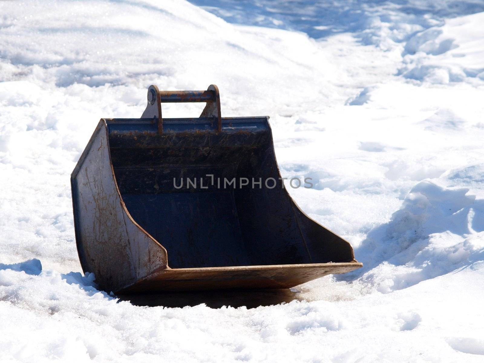 Shovel of a digging machine, isolated in snow