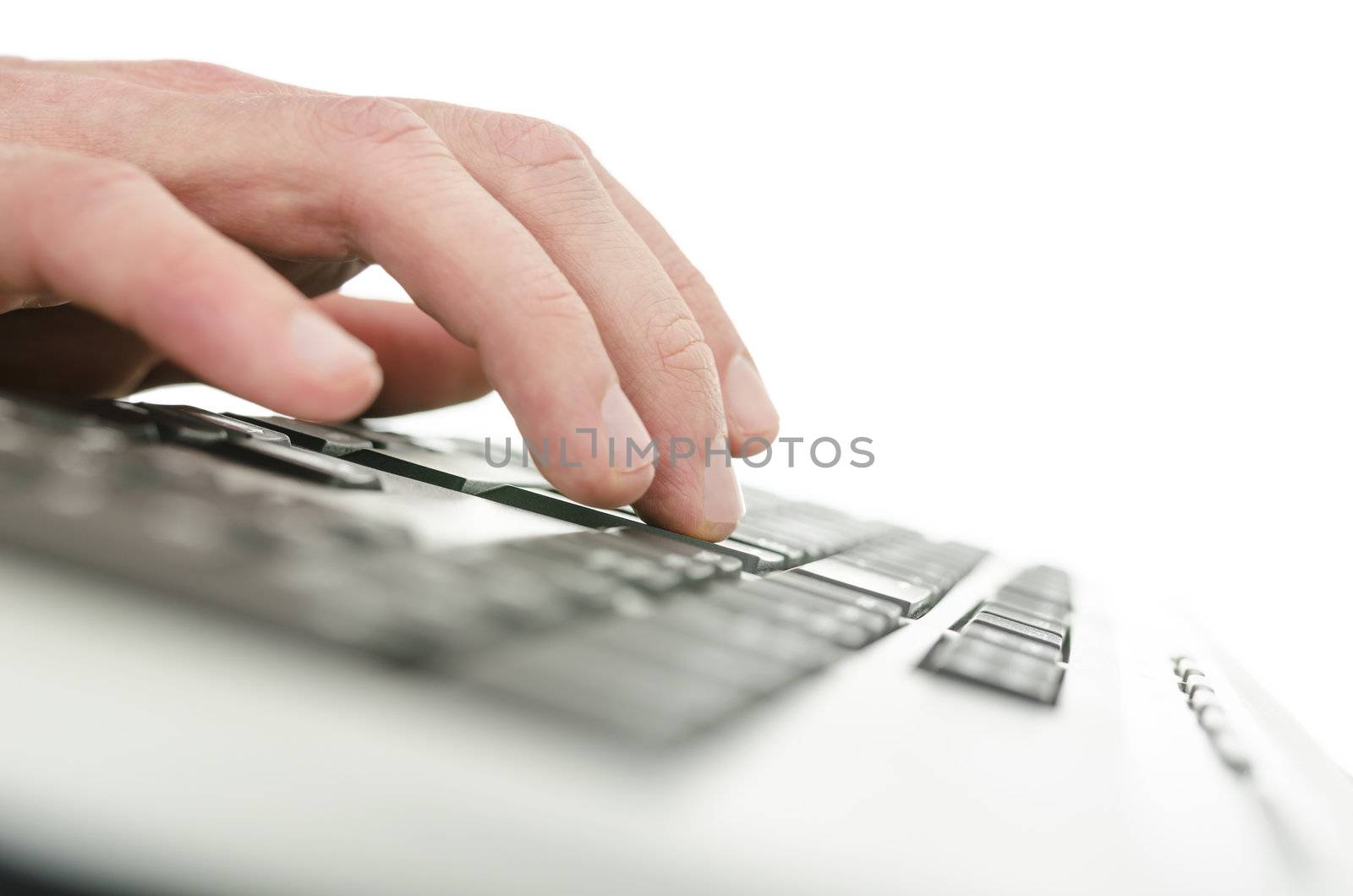 Closeup of young male hand typing on computer keyboard. Shallow dof.