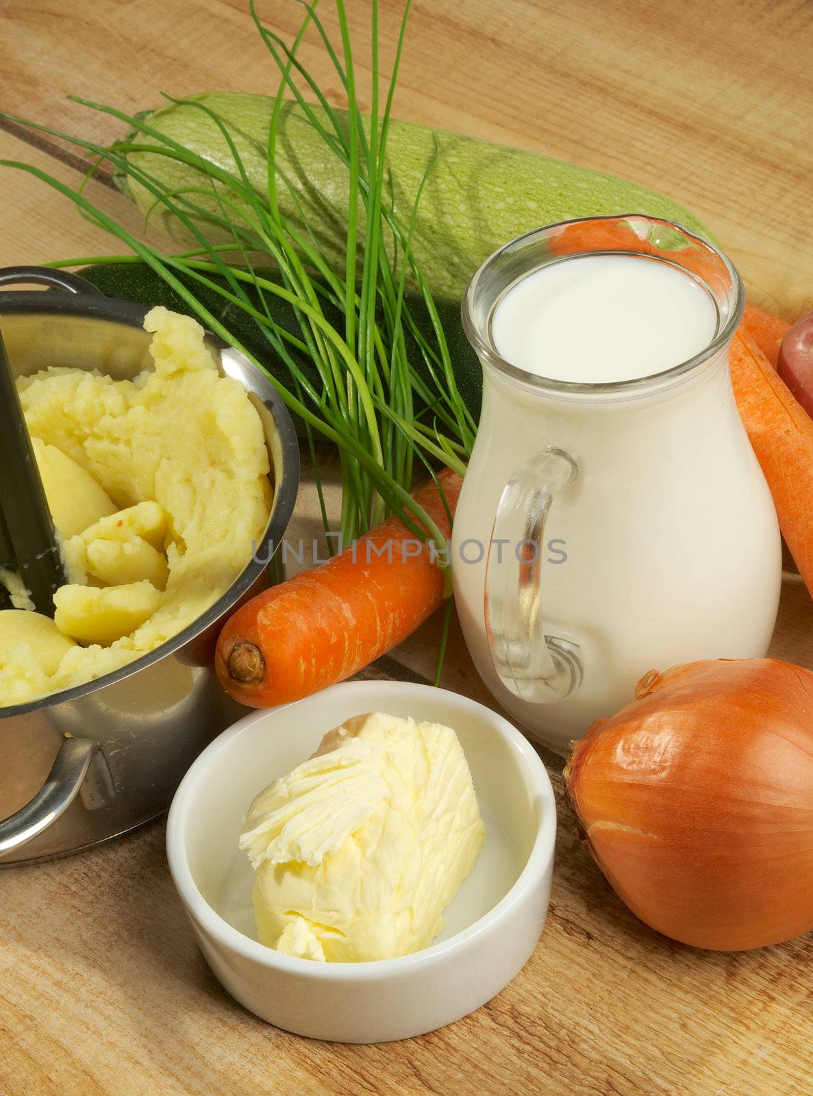Preparing Vegetables Puree. Mashed Potato, Jar of Milk, Butter, Onion, Carrot, Greens and Zucchini closeup on Wooden background