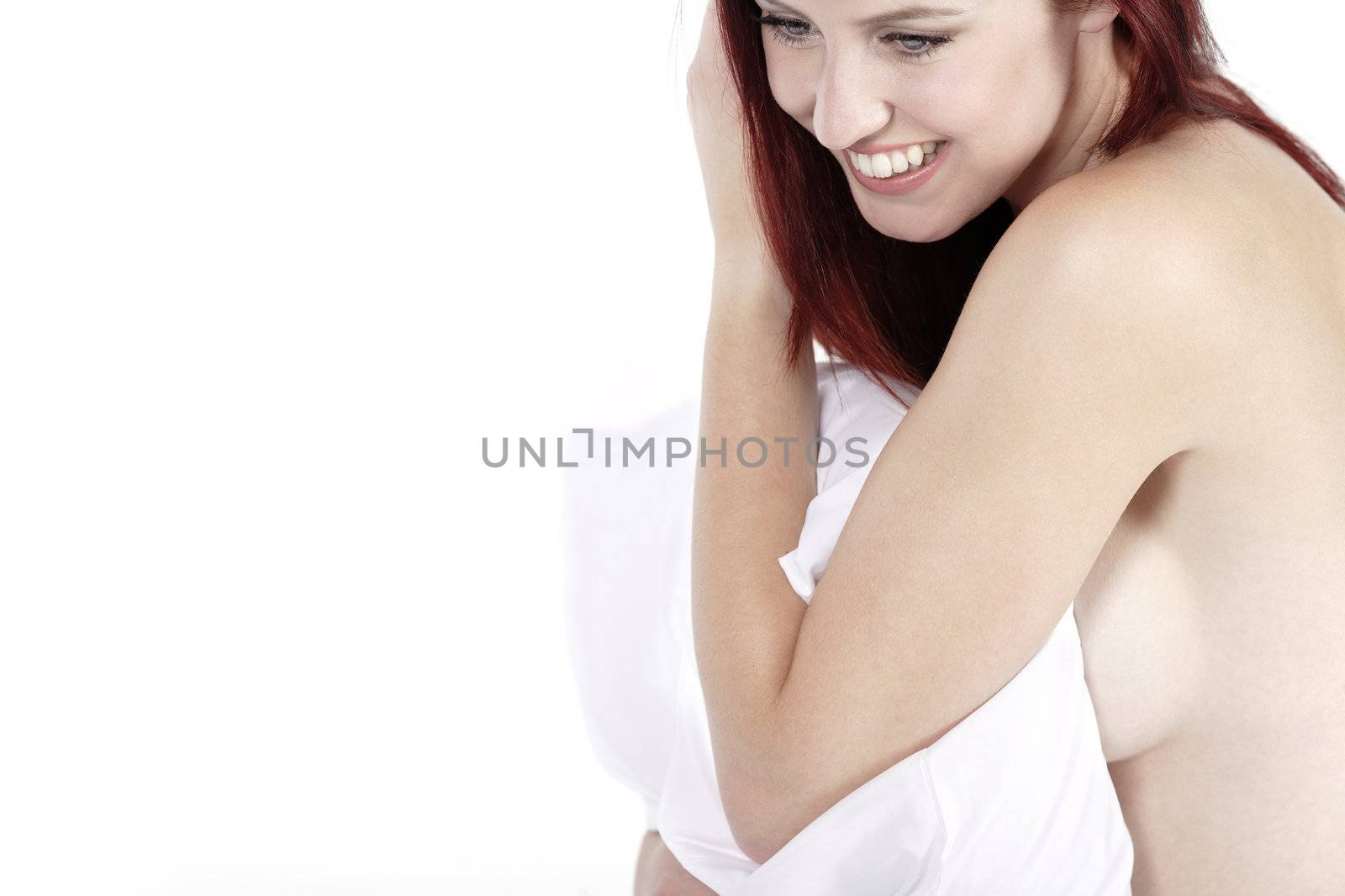 Attractive young woman holding a pillow on her bed at home