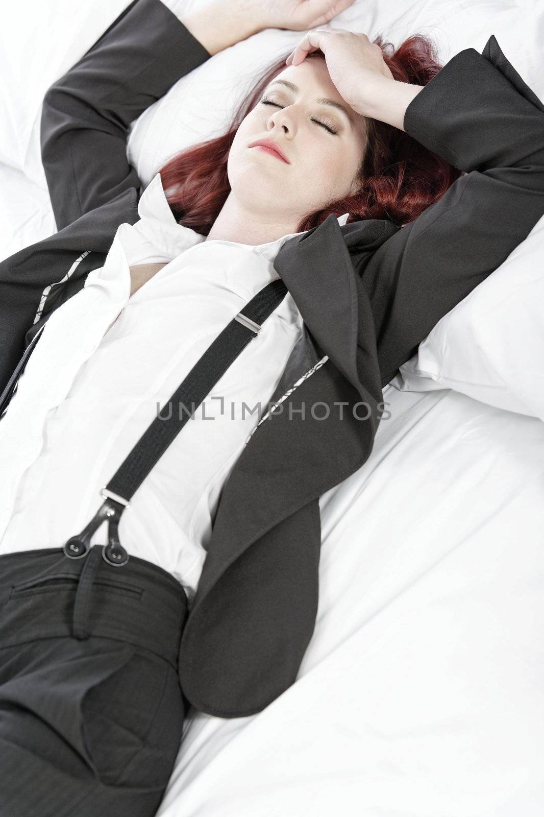 Business woman resting on bed by studiofi