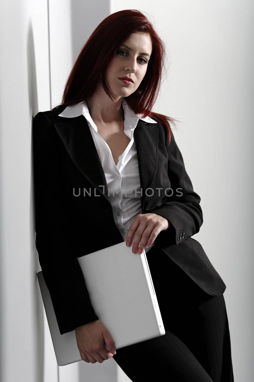 Professional business woman holding a white laptop at work