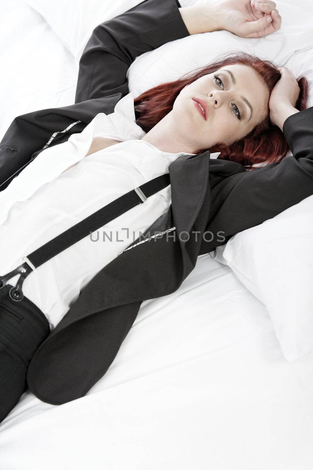 Business woman resting on bed by studiofi