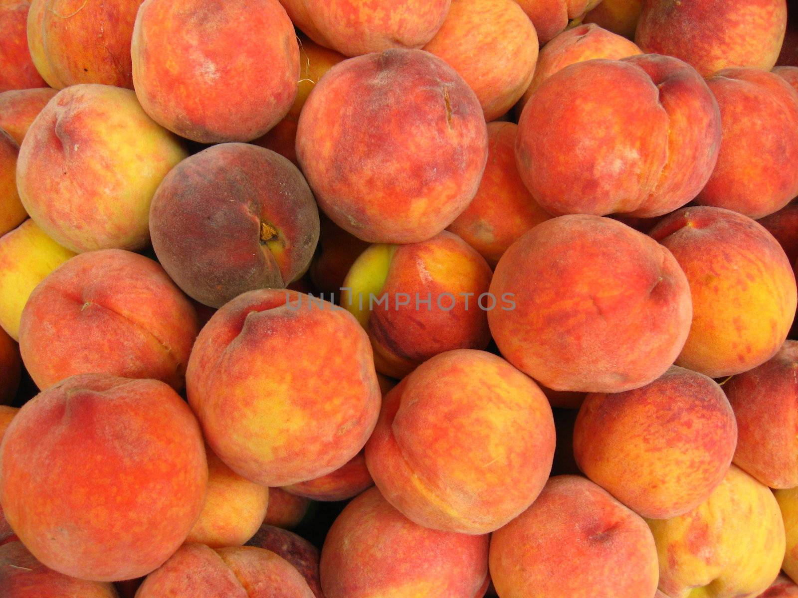 Many bright tasty peaches laying in the market