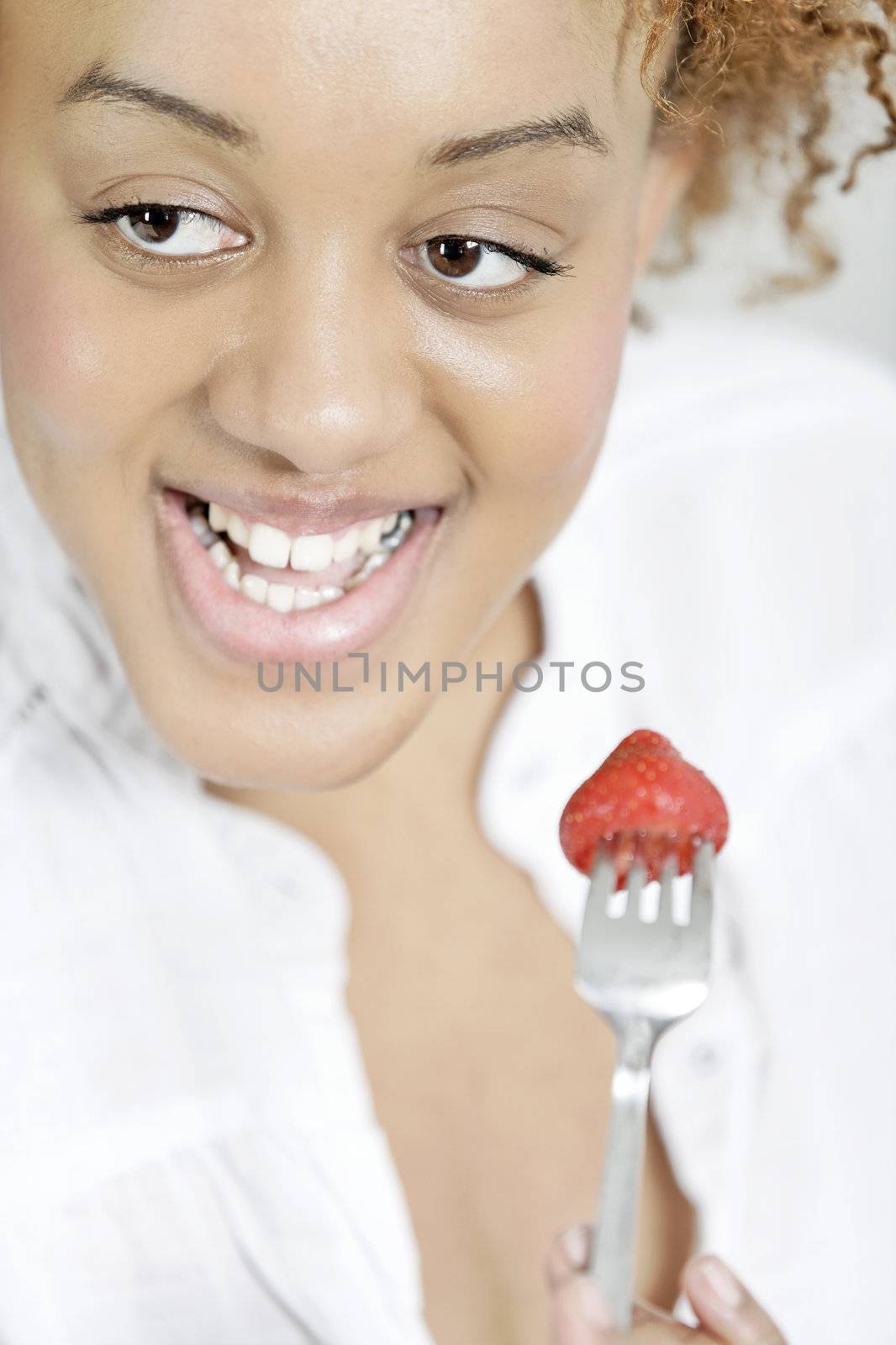 Beautiful young woman enjoying a bowl of fresh strawberries.