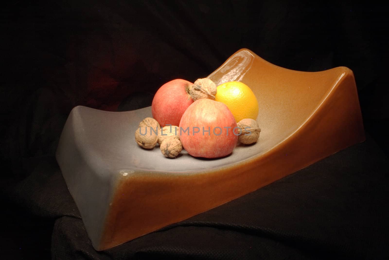 aplle, orange and nuts on the black background