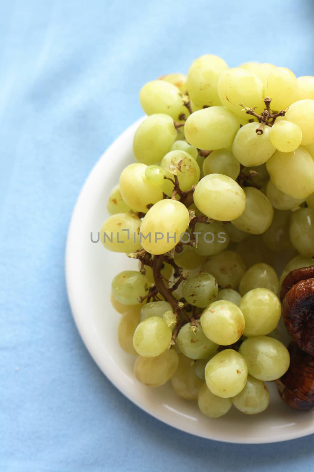 grapes on the plate on the blue background