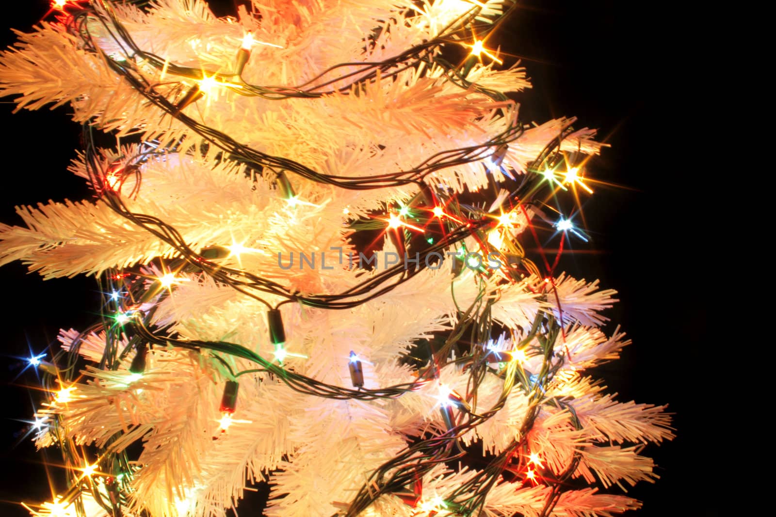 detail of xmas tree with color lights on the black background