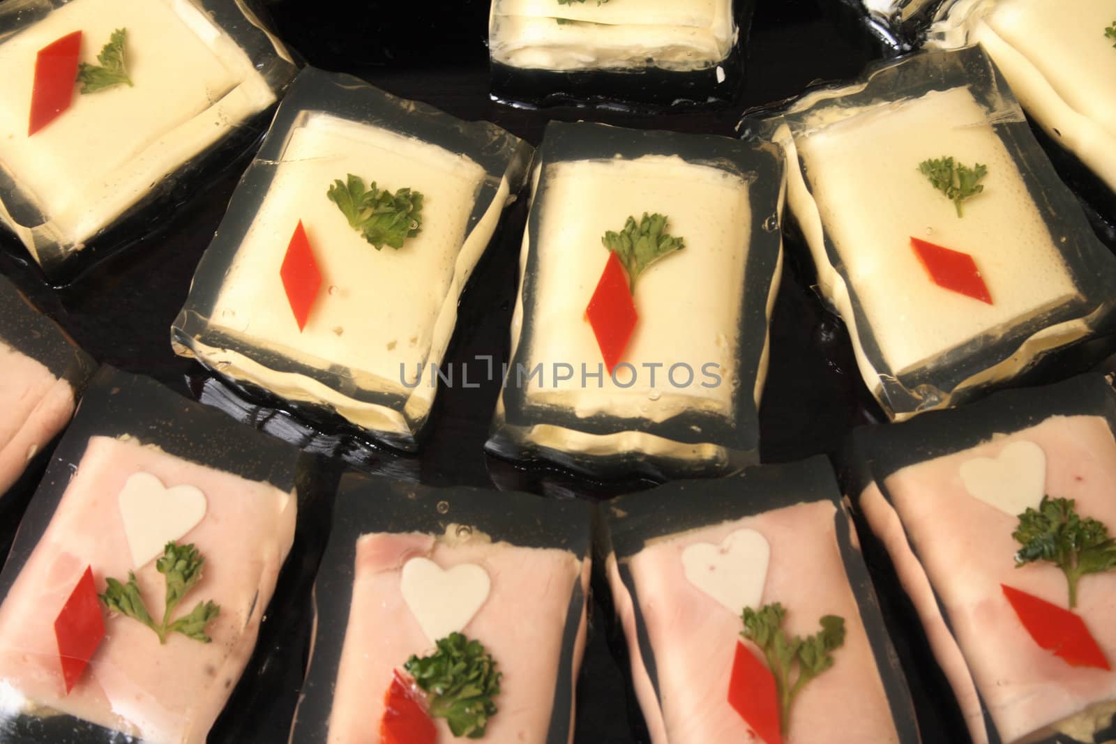 cheese and salami in the aspic on the black background