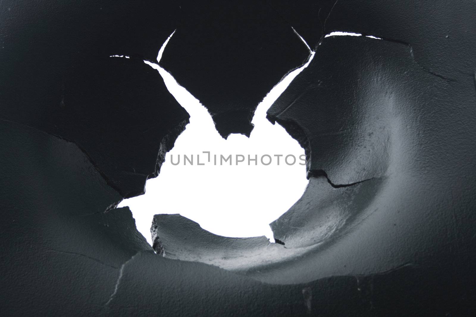 hole in the metal with white background behind it