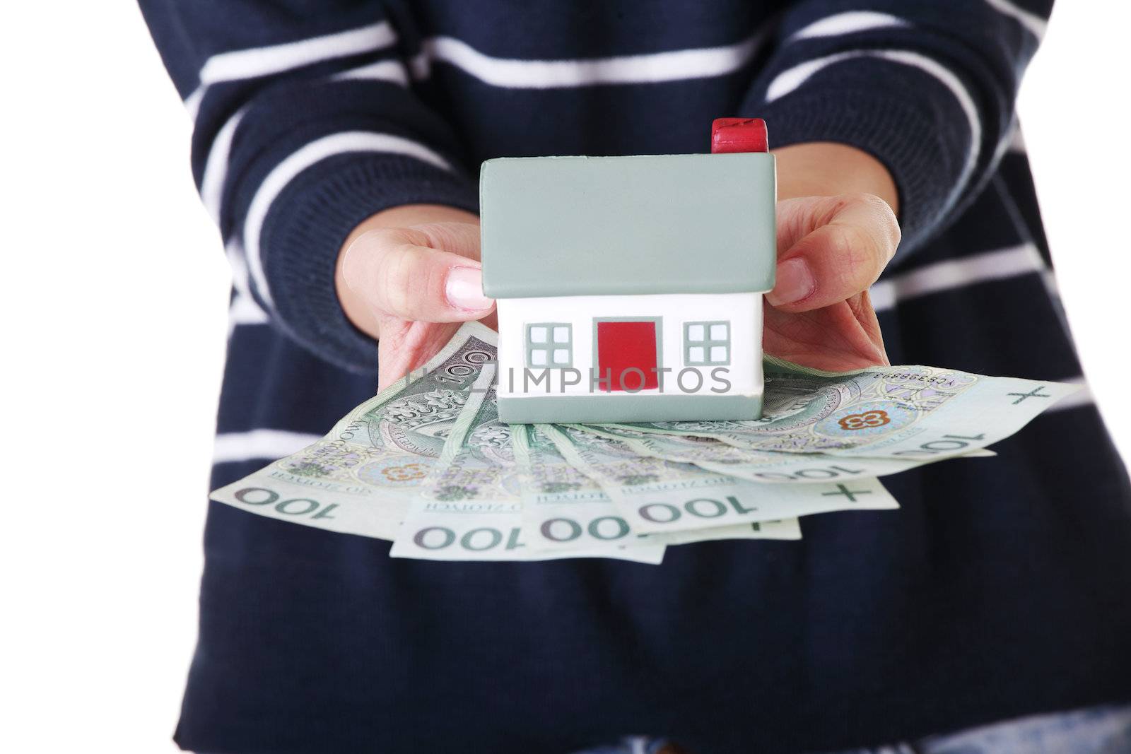 Woman holding PLN ( polish zloty ) bills and house model over white - real estate loan concept