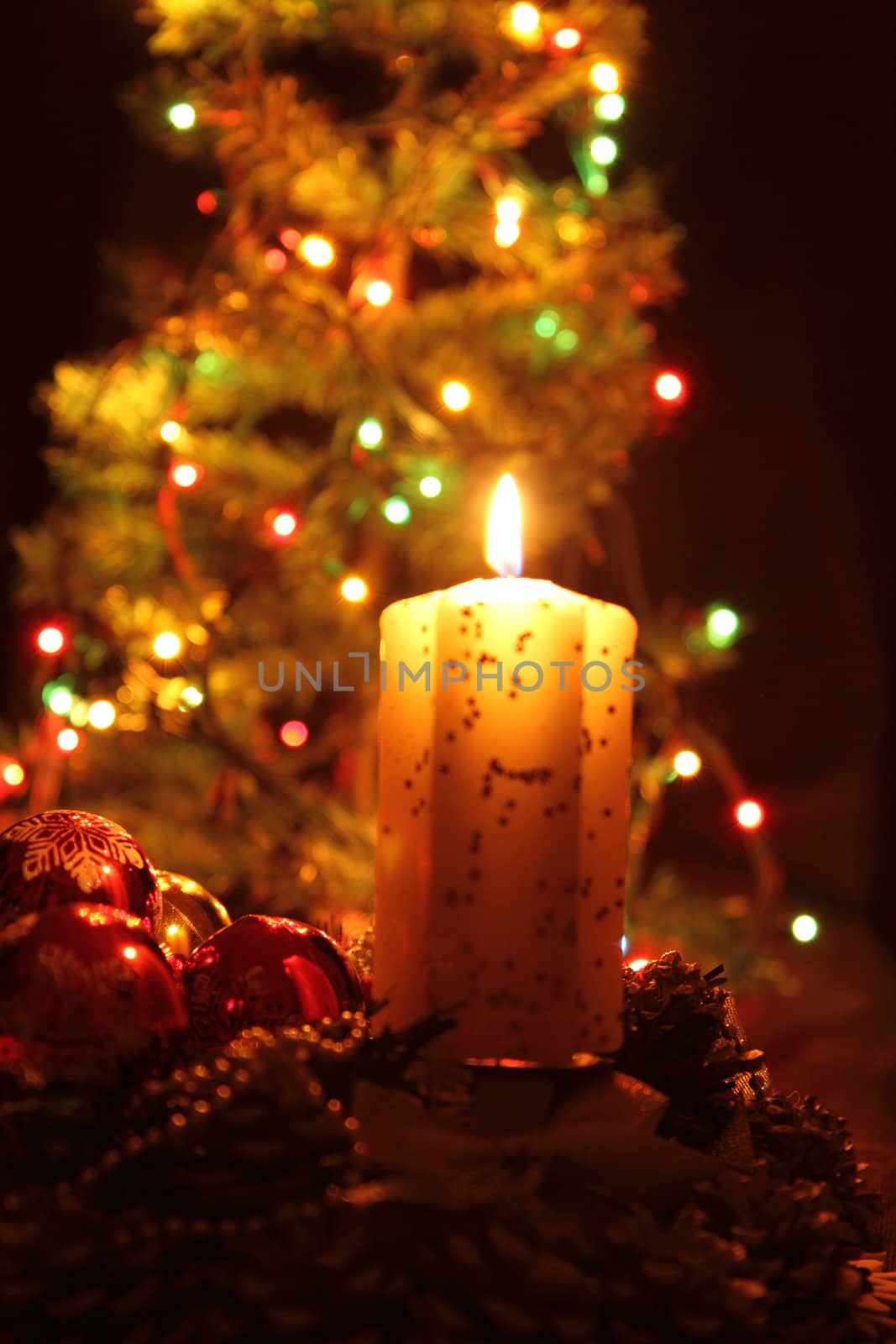 candle and the christmas tree in the dark night 