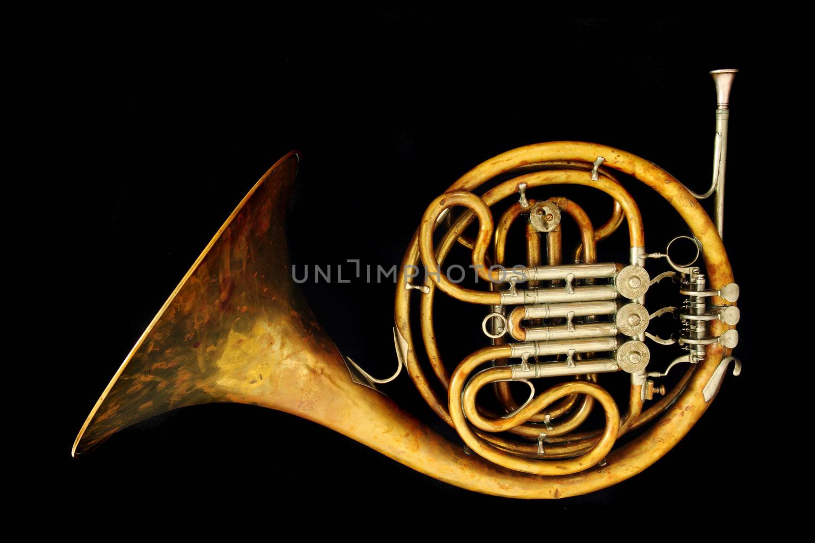 old french horn isolated on the black background