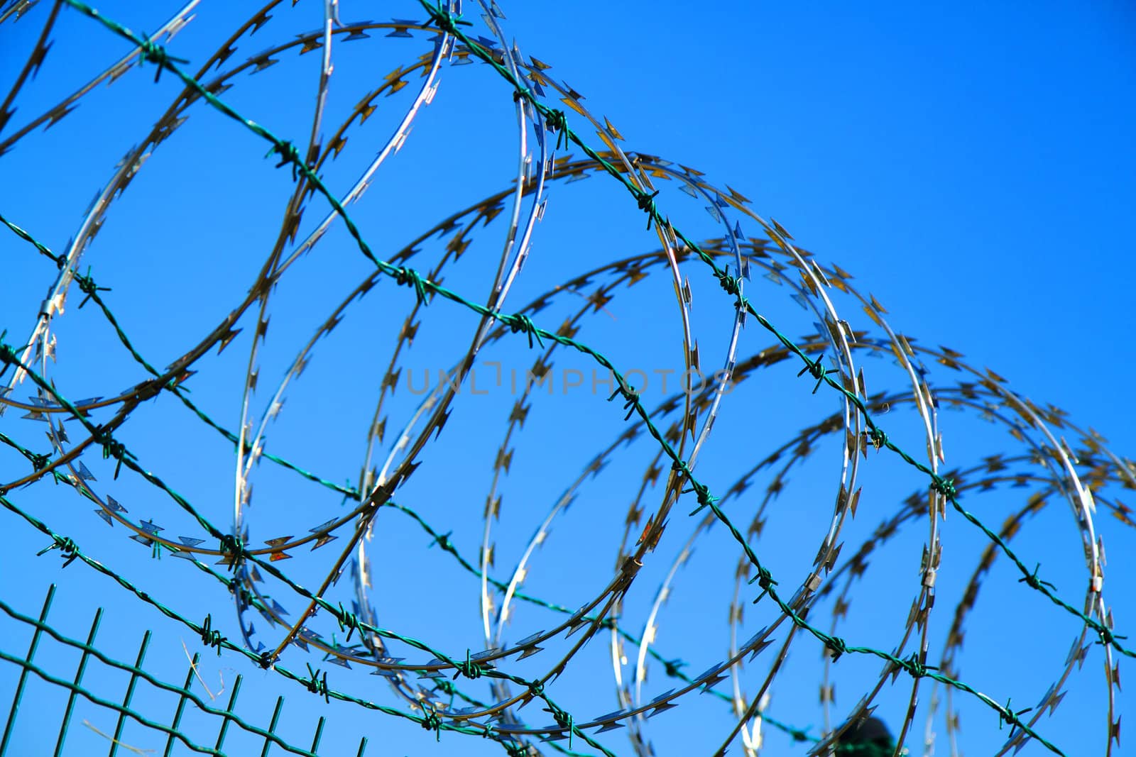 barbed wire against blue sky  by jonnysek