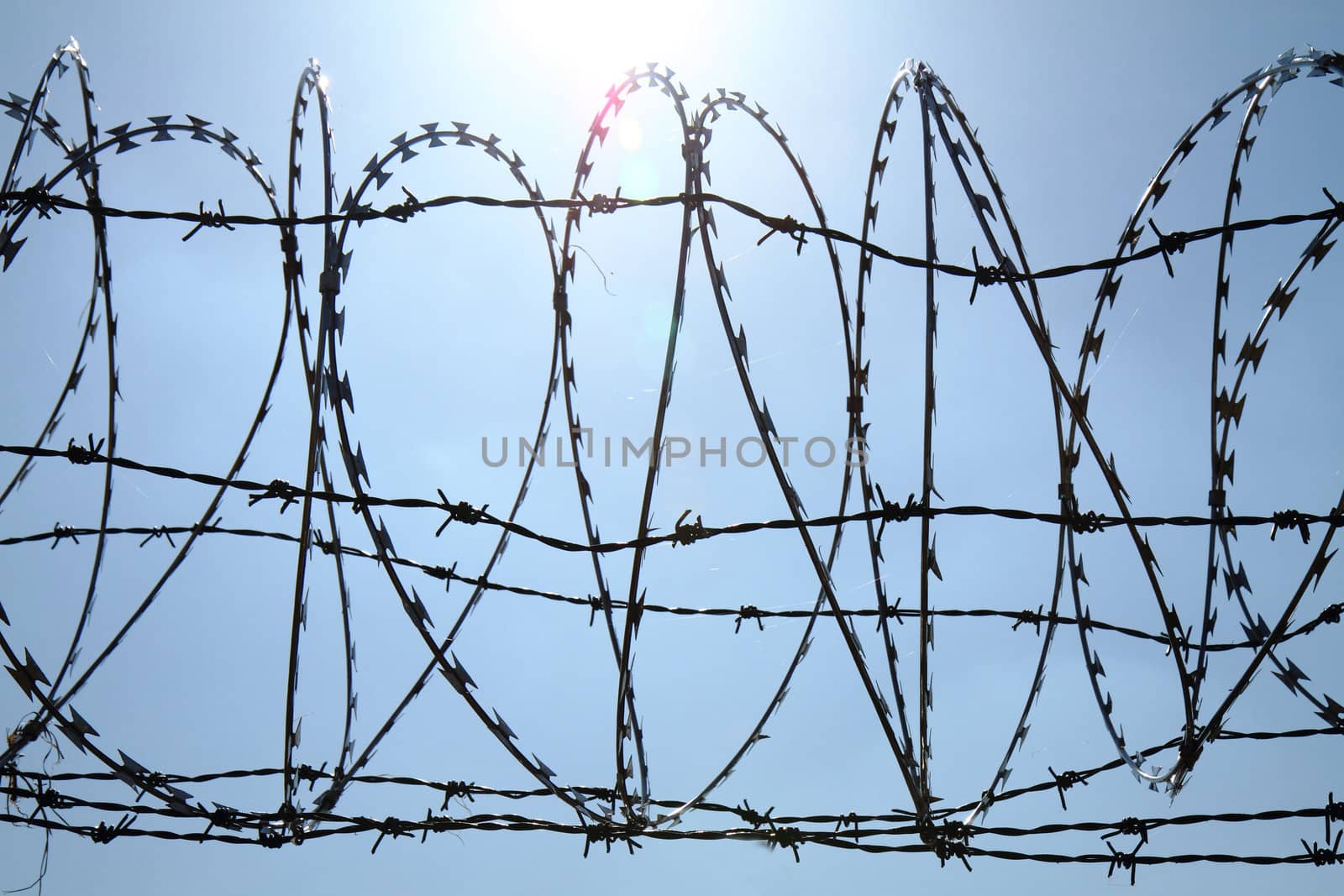 barbed wire against blue sky  by jonnysek