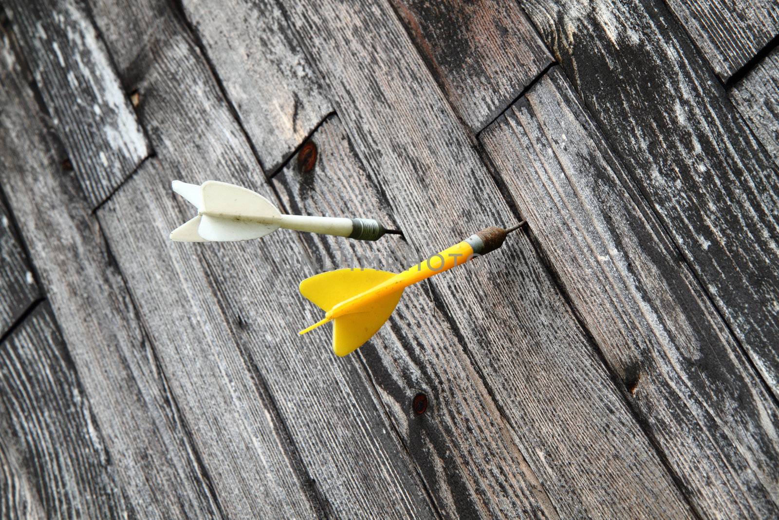 old plastic sport darts in the wooden background