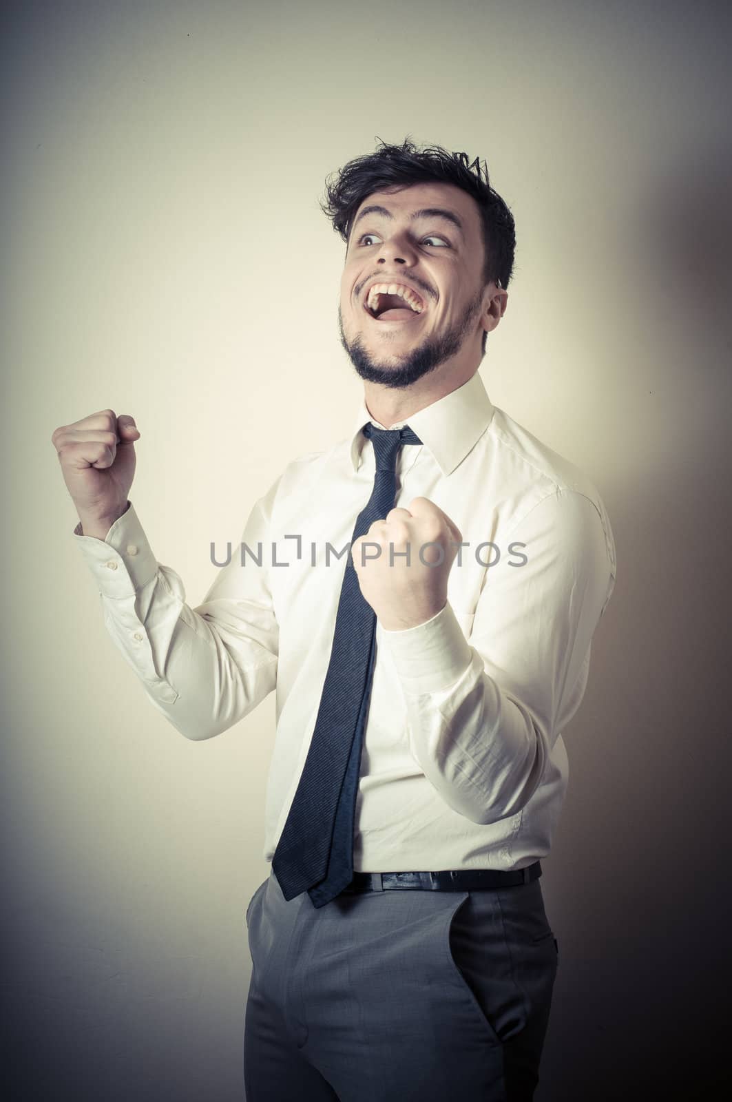 happy successful stylish businessman on gray background