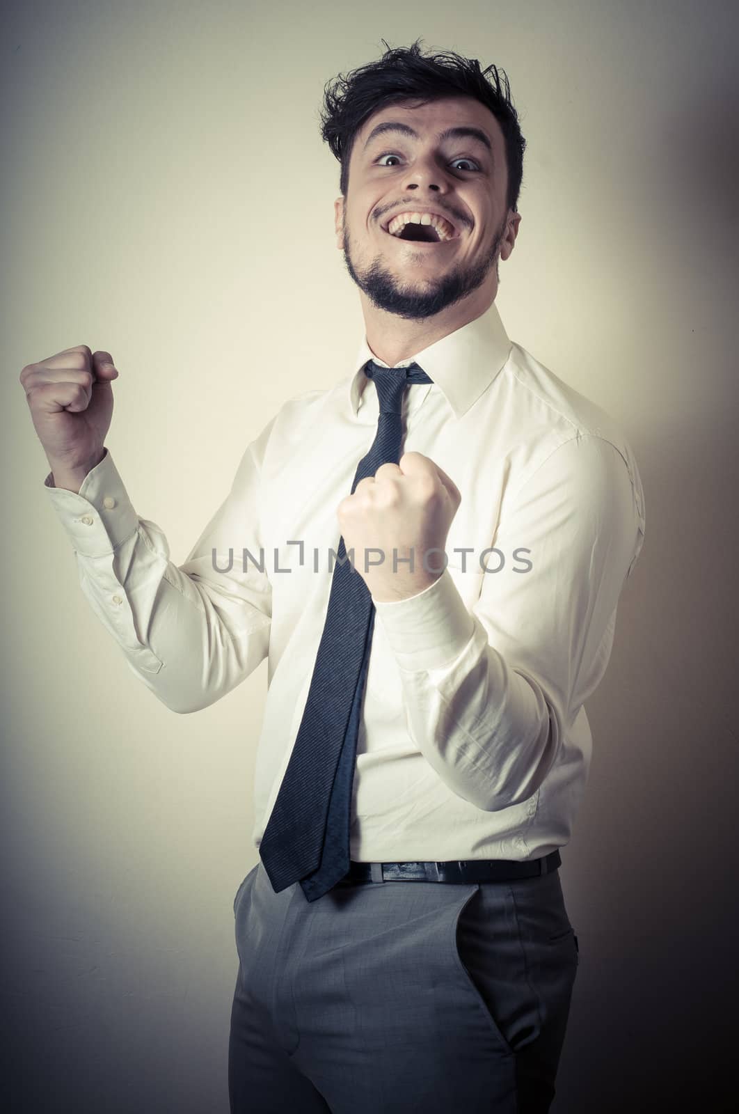 happy successful stylish businessman on gray background