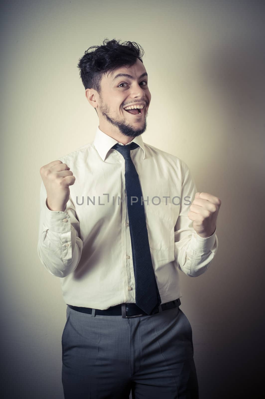 happy successful stylish businessman on gray background