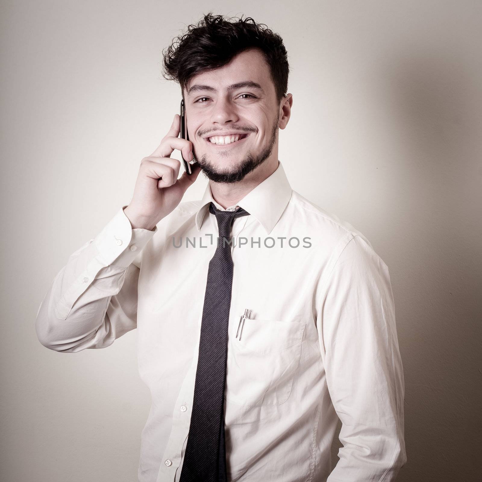 stylish business man on the phone on gray background