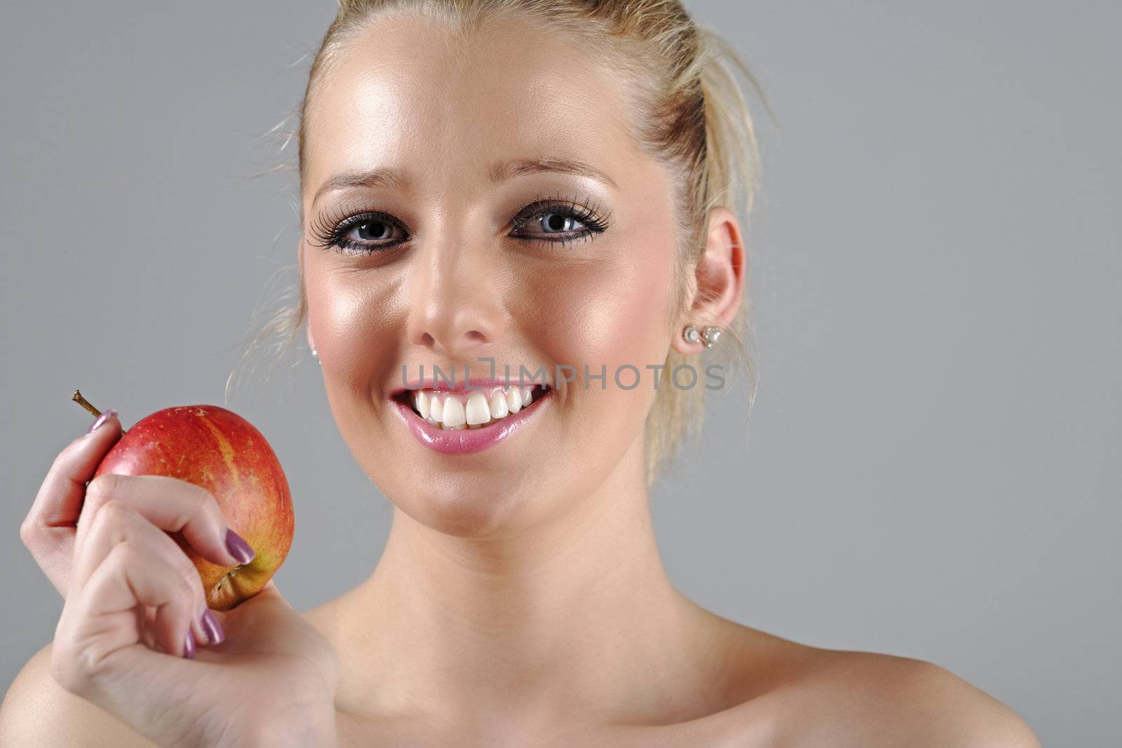 Beautiful young woman in beauty style pose holding an apple