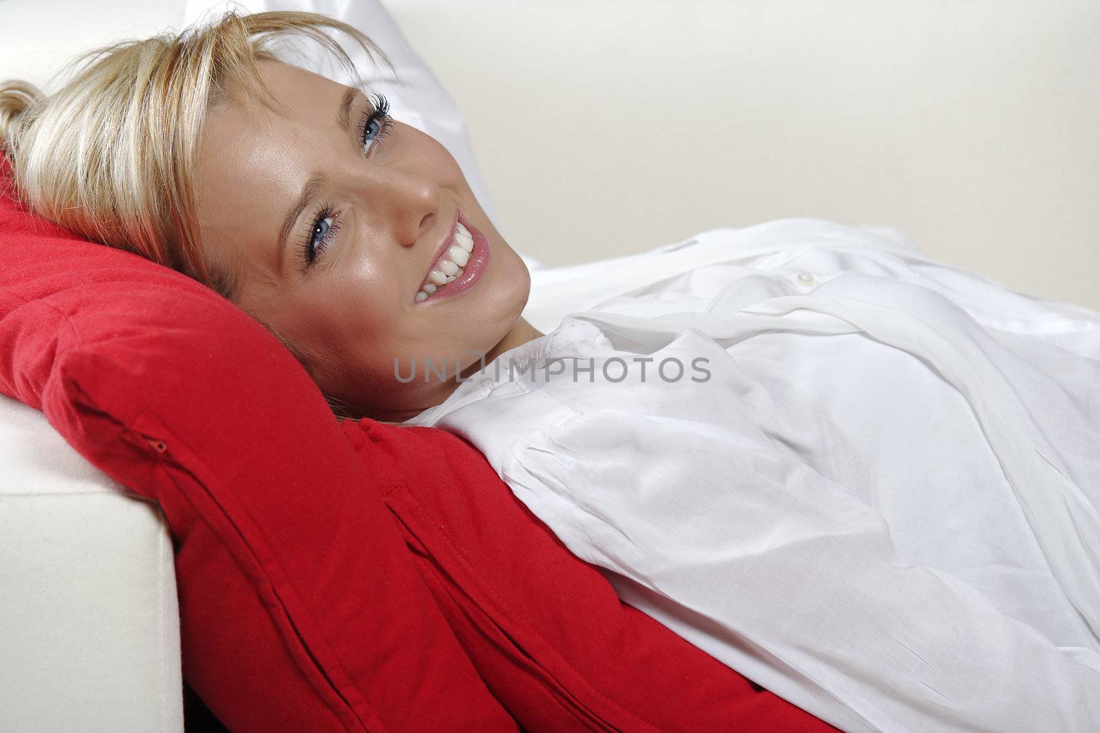 Beautiful young woman lying on sofa at home