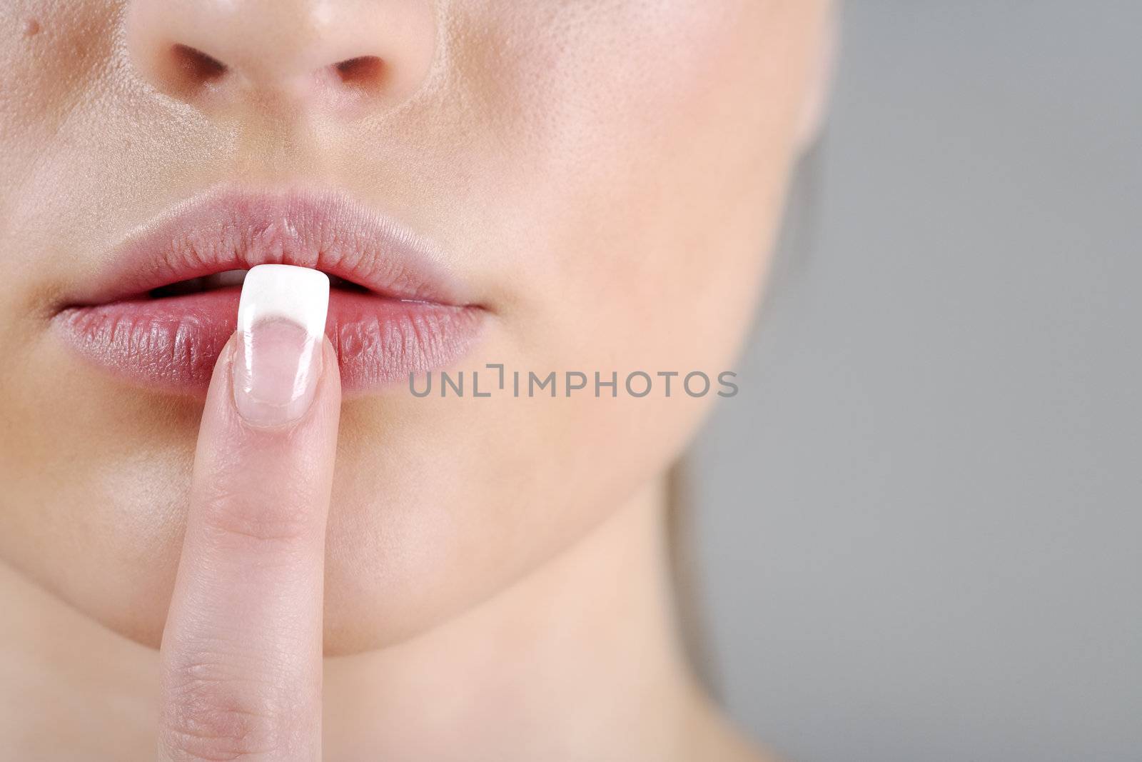 Young woman in a beauty style pose with her finger over her mouth