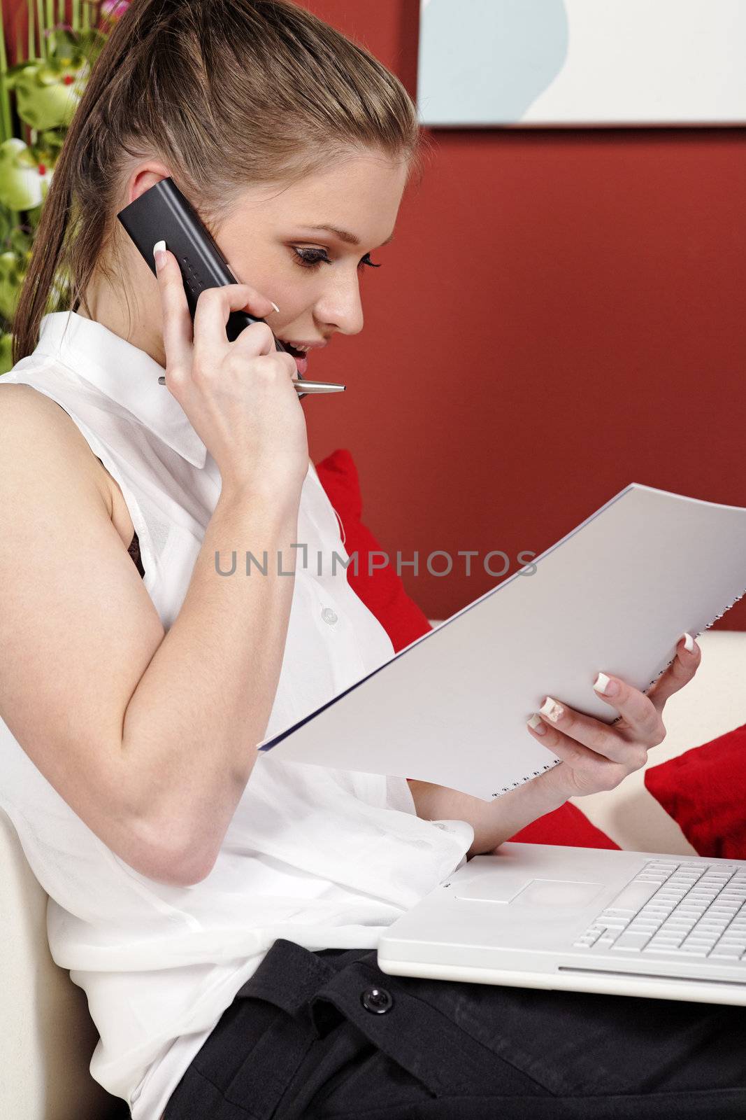 Young woman working from home reading documents