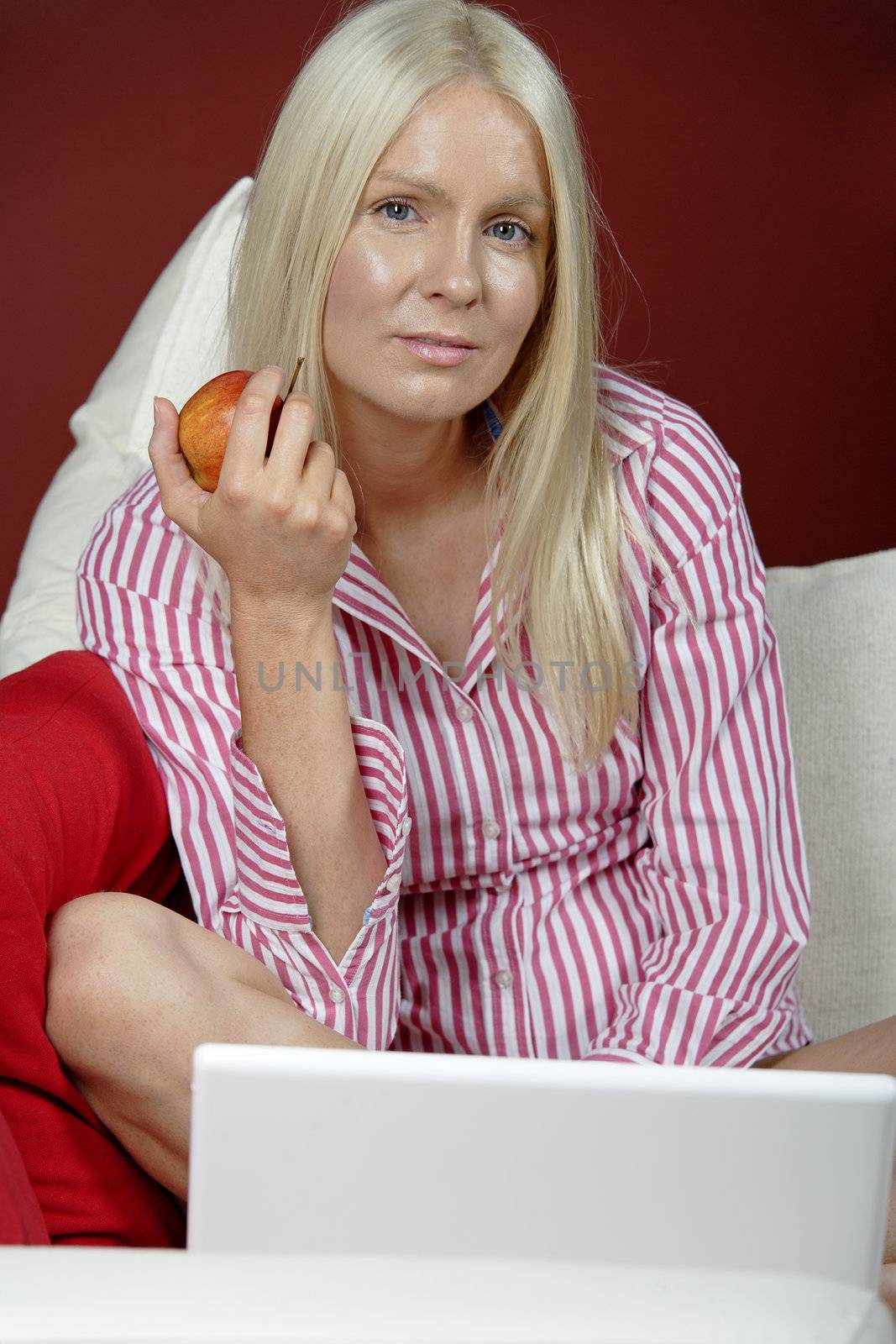 Young woman on her sofa at home using a laptop computer