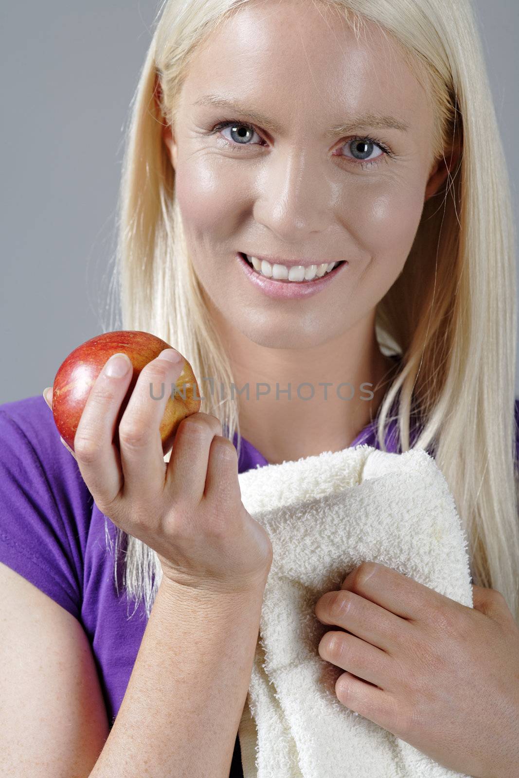 Young woman with an apple and resting after workout.