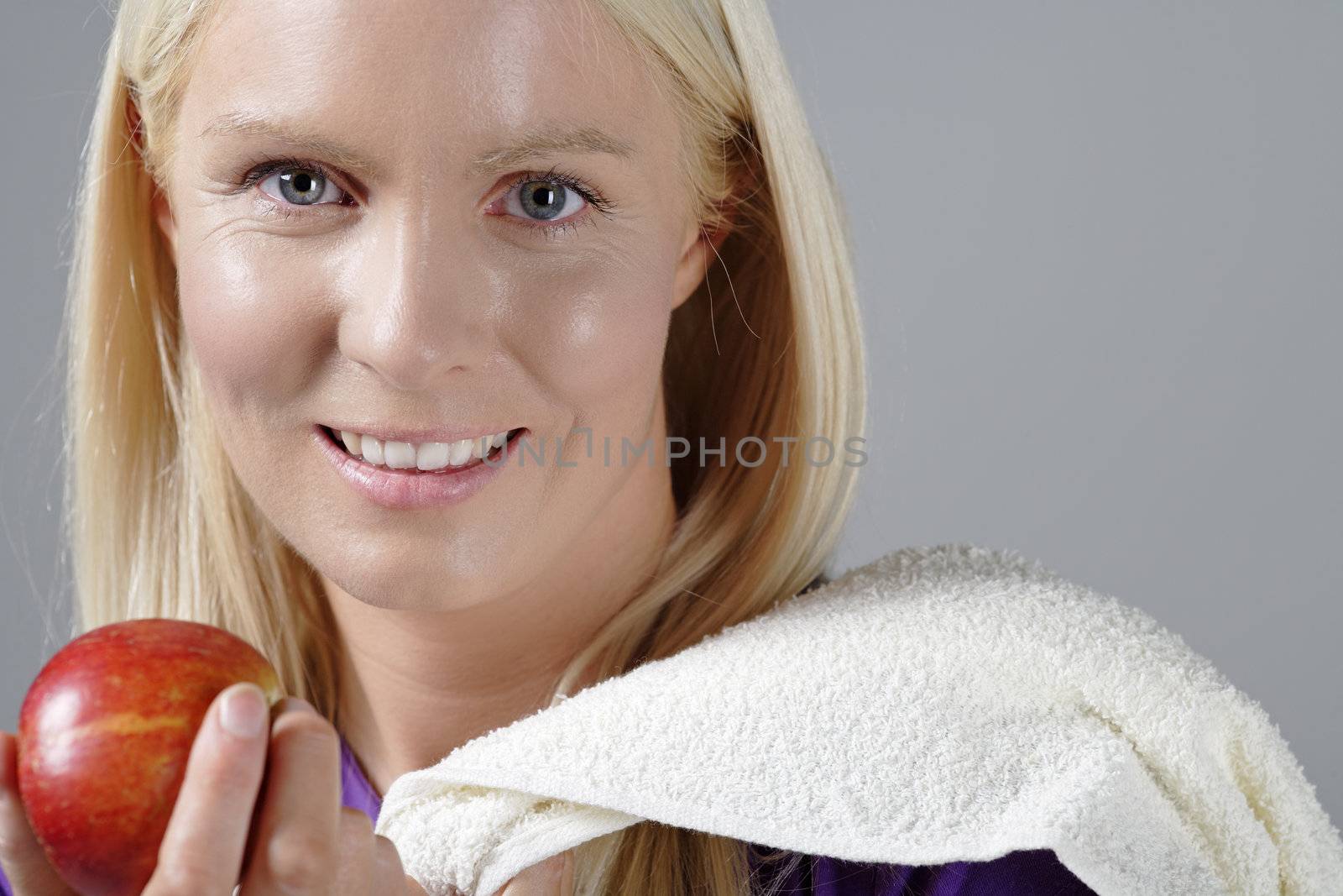 Woman holding apple after fitness by studiofi