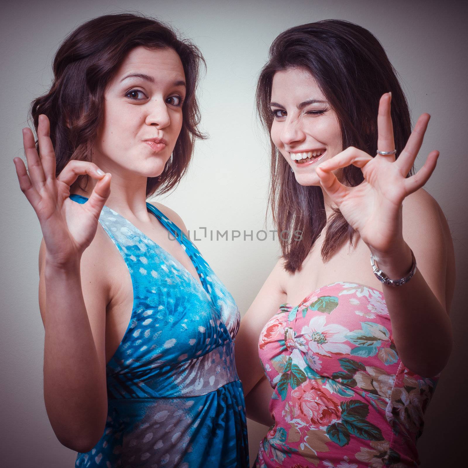two beautiful girls positive on gray background