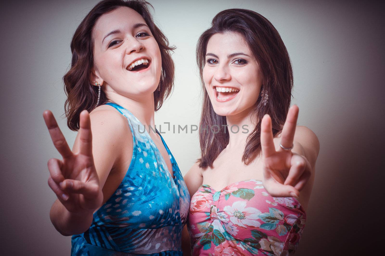 two beautiful girls positive on gray background