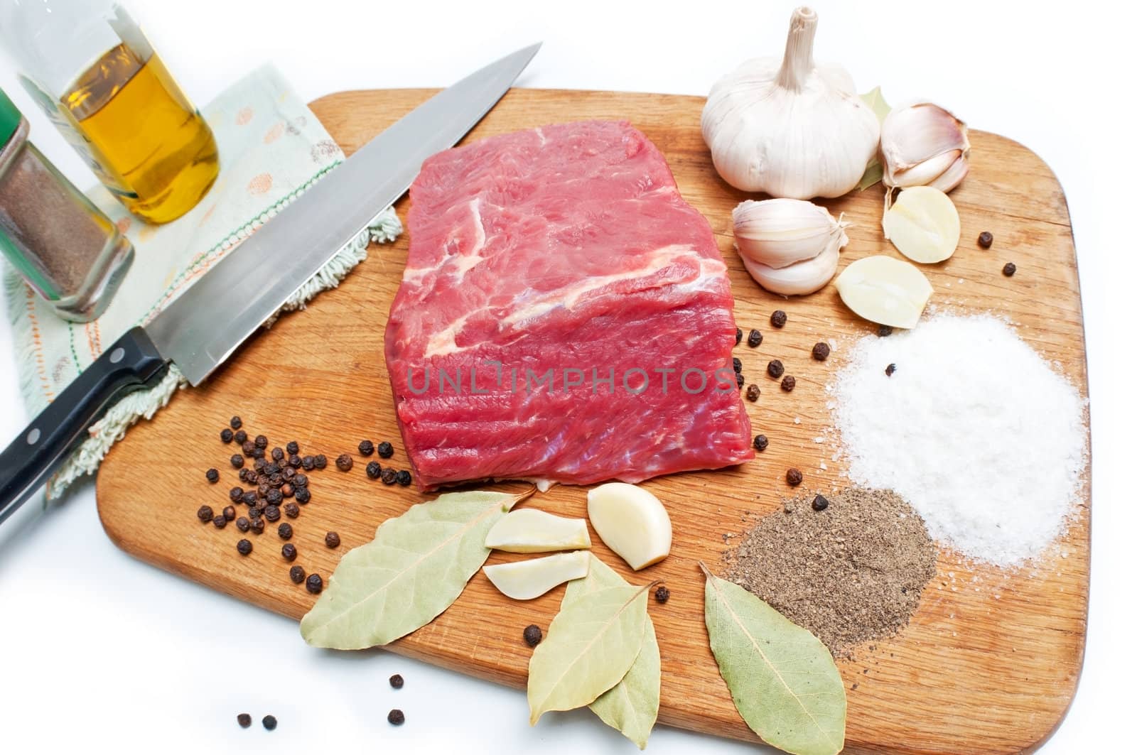 Fresh raw beef meat  on board with salt, pepper, garlic  and spices