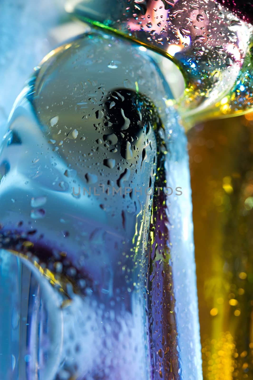 Bright colorful abstract background. Glass and drops of water. Closeup.