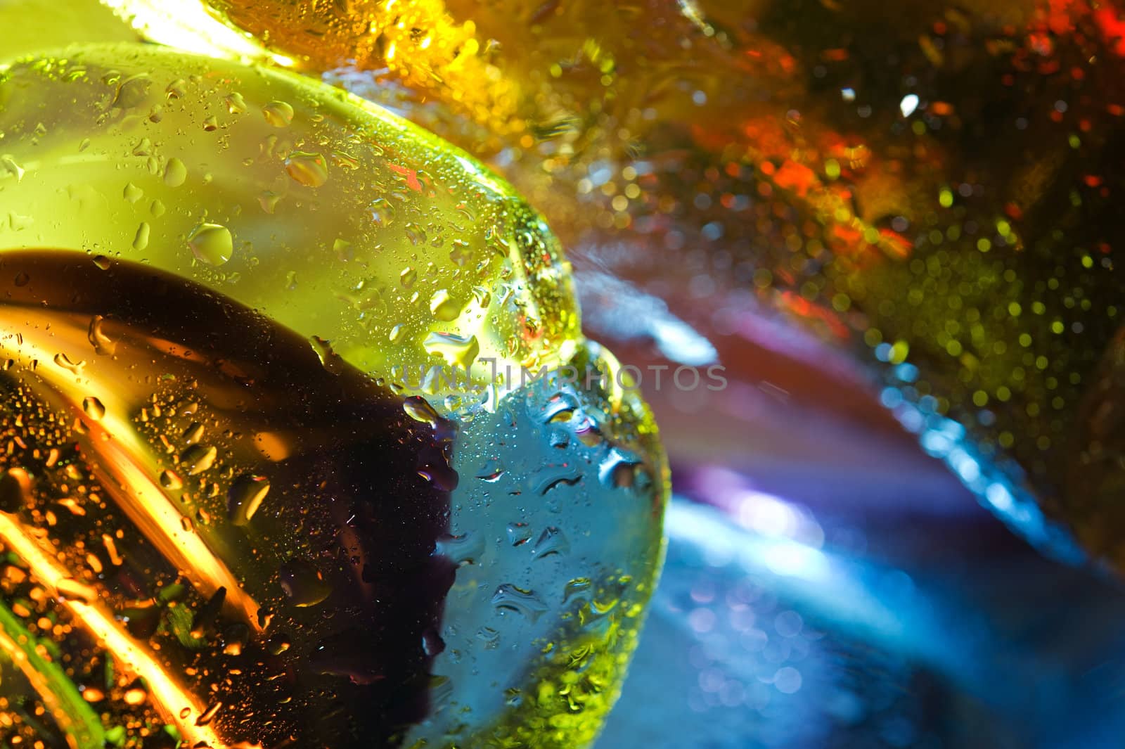 Bright colorful abstract background. Glass and drops of water. Closeup.