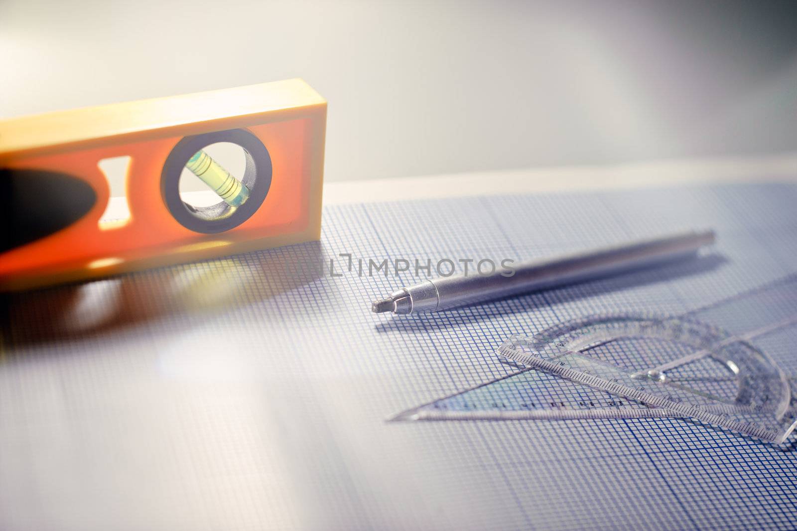 Pencil, graph paper, water level and ruler. Workplace Designer. Shot with shallow depth of field. Selective focus.