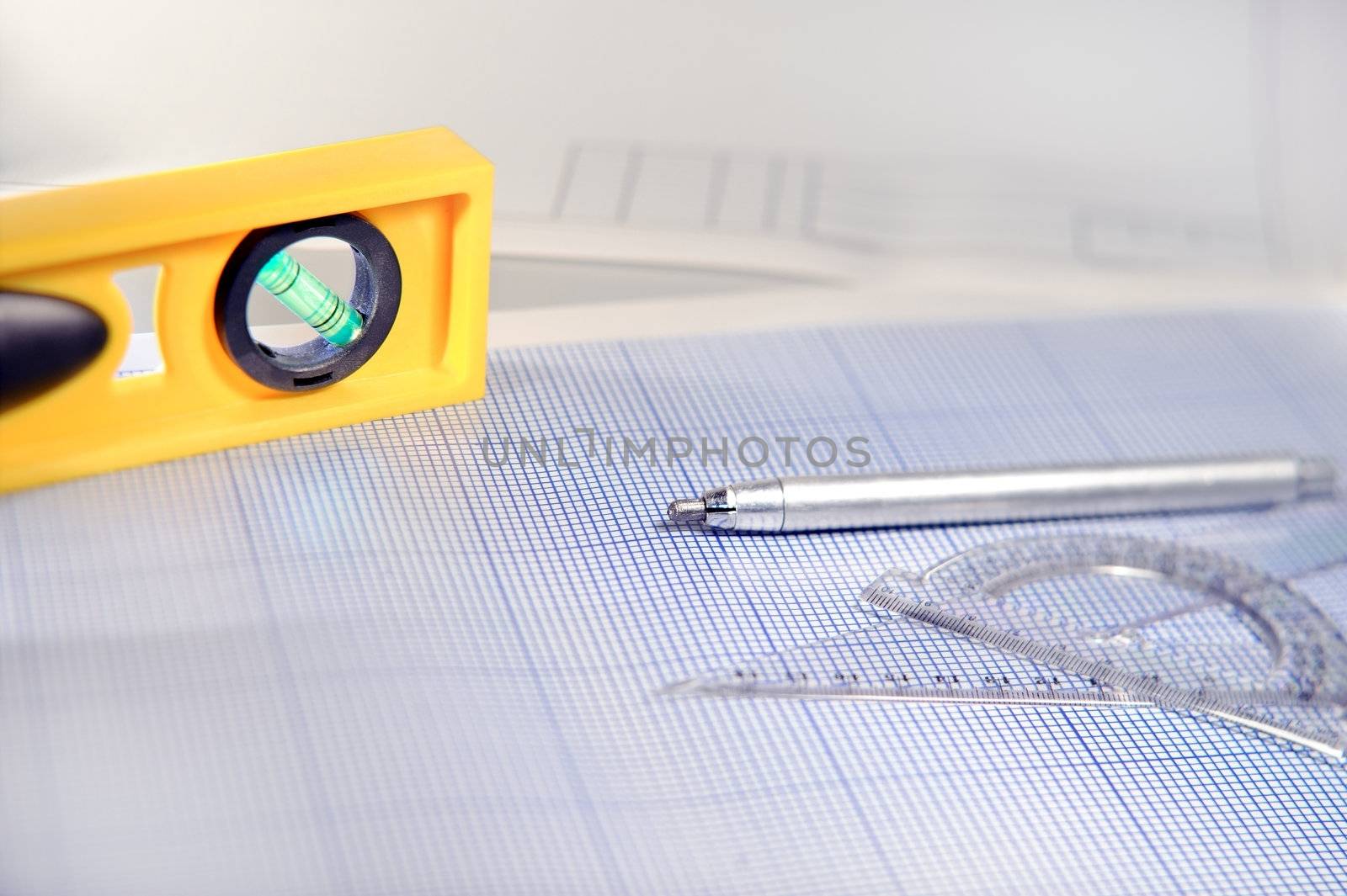 Pencil, graph paper, water level and ruler. Workplace Designer. Shot with shallow depth of field. Selective focus.