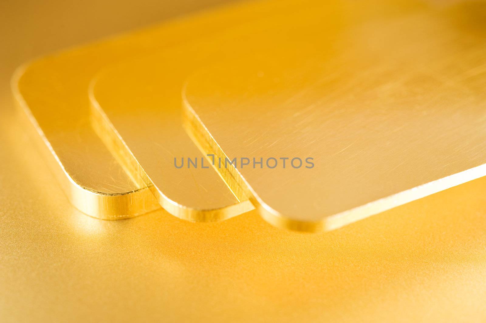 stack of pure gold ingots on a golden background