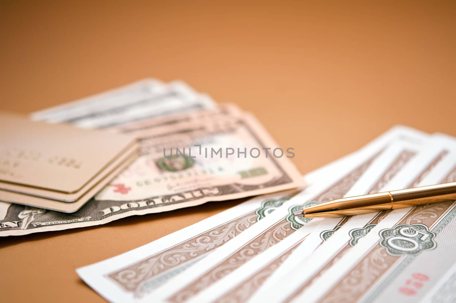 golden pen, money and bank card. closeup. shallow depth of field.