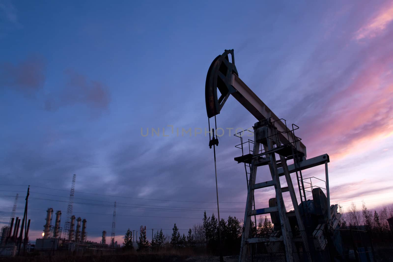 oil pump on  background of  industrial landscape and sunset sky