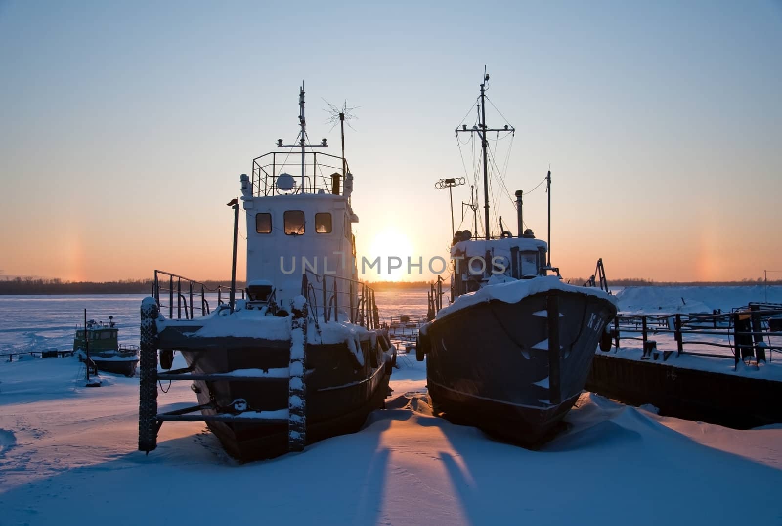 Ships covered with snow on coast Ob River, await  season of navigation. winter sunset, Siberia, Surgut city.