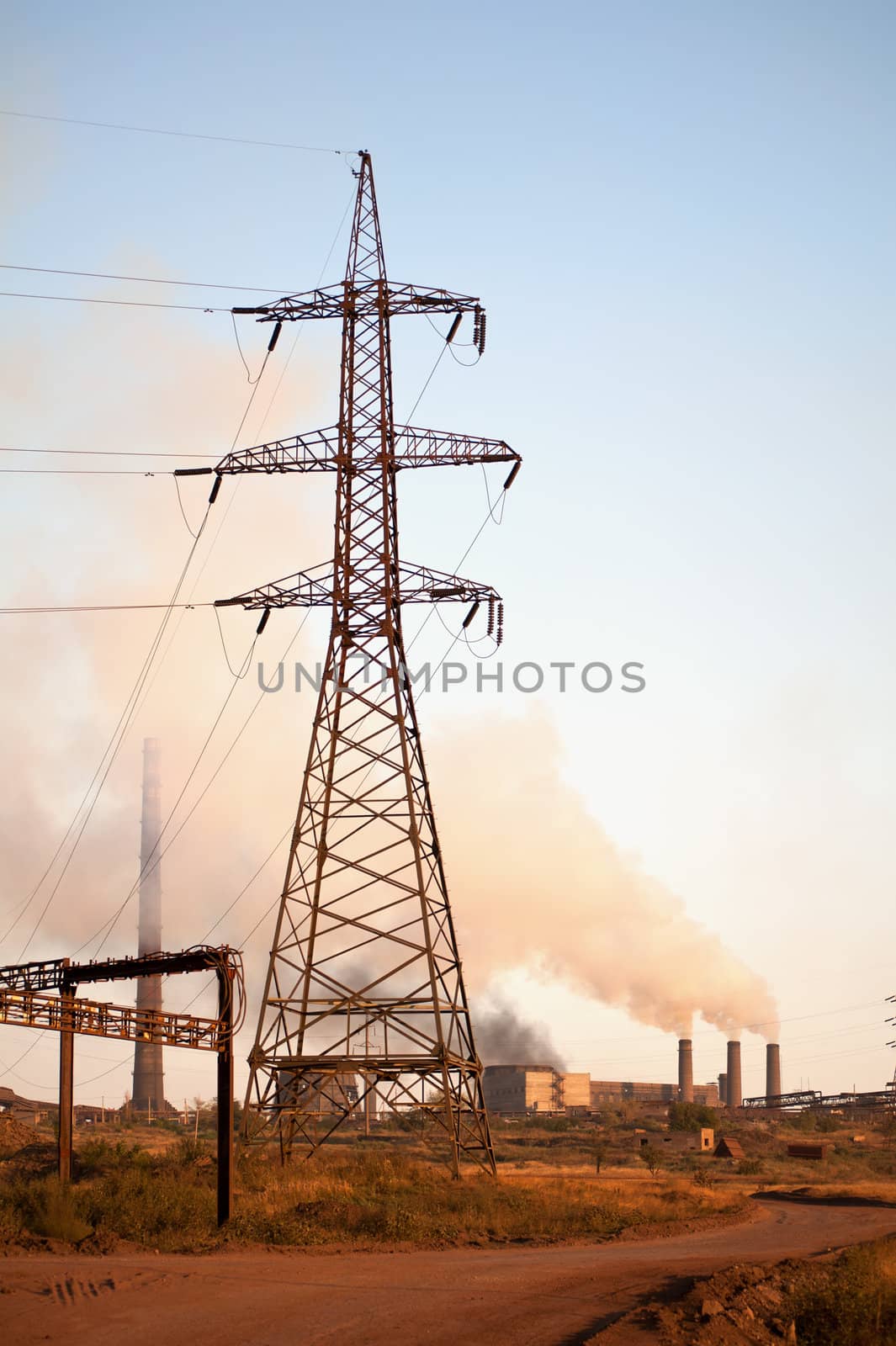 High voltage tower and old steel factory. Smoke. Industria landscape.