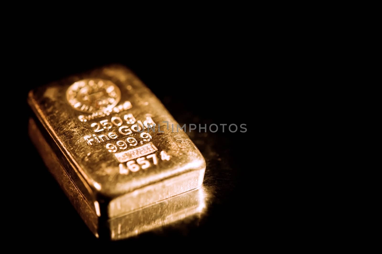 fine gold ingot isolated on a black background.  shallow depth of field.